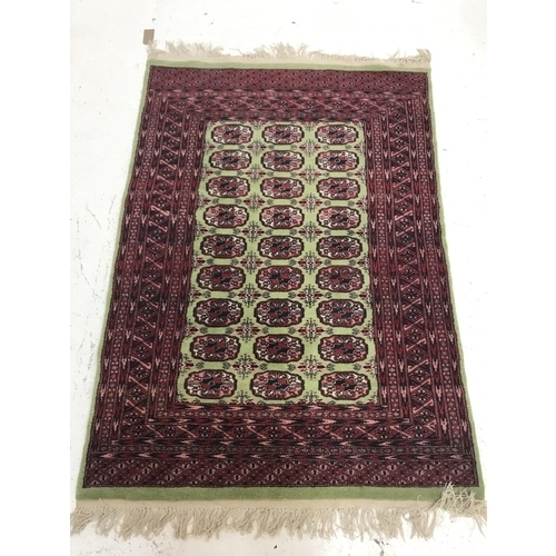392 - ISHFAN STYLE RUG
with a lime green border and central panel with rosette decoration encased by a mul... 