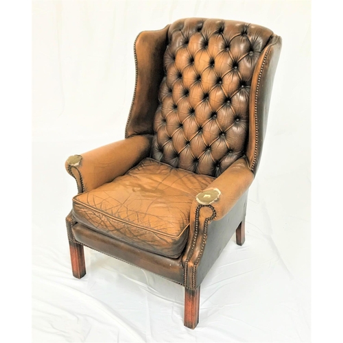 462 - CHESTERFIELD WING BACK ARMCHAIR
in mustard leather with decorative stud detail, standing on front mo... 