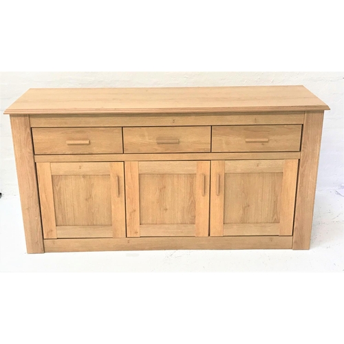 99 - LARGE LIGHT OAK SIDE CABINET
with a moulded top above three frieze drawers with three panelled cupbo... 