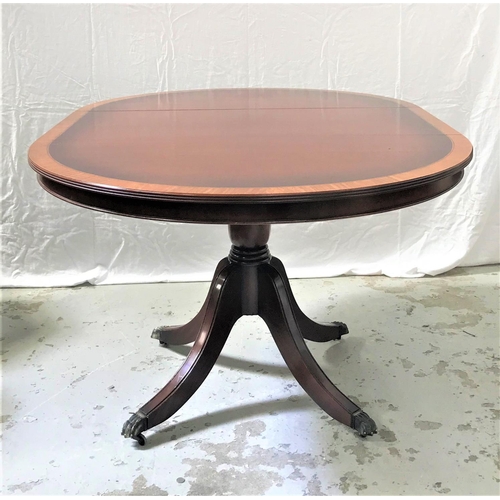 100 - MAHOGANY AND CROSSBANDED CIRCULAR DINING TABLE
with a pull apart top and extra leaf, standing on a t... 