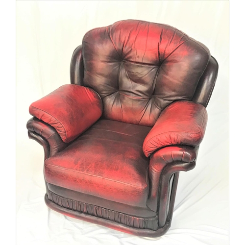 108 - LEATHER ARMCHAIR
in red leather with a deep padded back, seat and arms, standing on stout bun feet