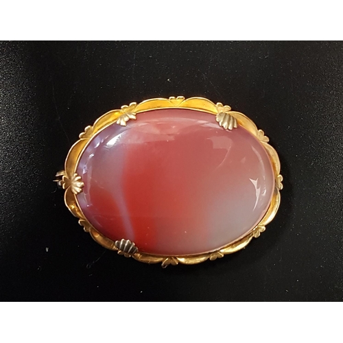 105 - AGATE SET BROOCH
the central oval orange and white agate secrion in unmarked gold mount, 4.5cm wide