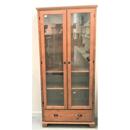 376 - WAXED PINE DISPLAY CABINET
the moulded top above a pair of glazed doors opening to reveal adjustable... 