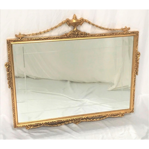 389 - ORNATE GILT FRAME WALL MIRROR
with urn and swag decoration around an oblong grooved plate, 92cm wide