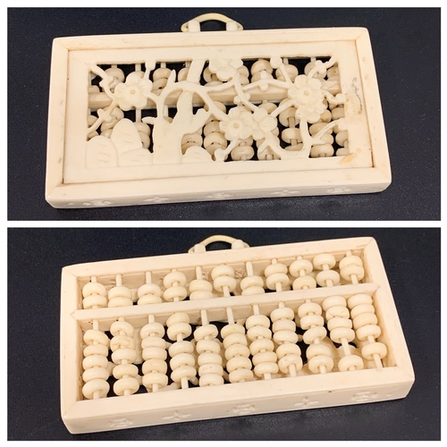 311 - CHINESE CARVED IVORY ABACUS
of rectangular form with fold over handle above carved circular counters... 