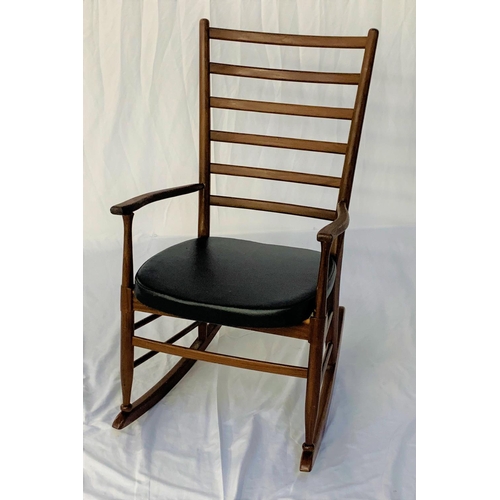 557 - TEAK ROCKING CHAIR
with a ladder back and shaped arms above a vinyl padded seat