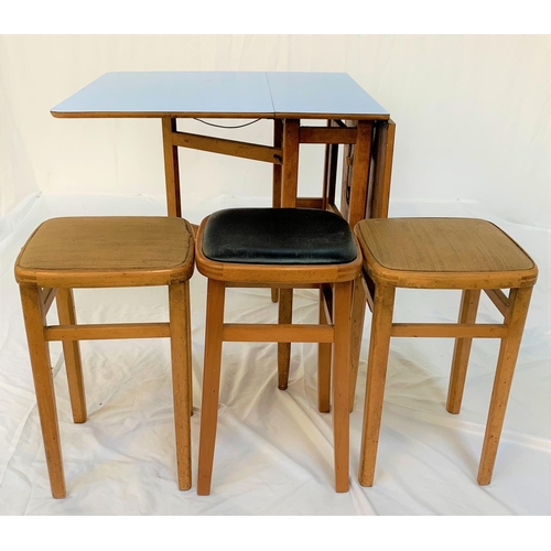 562 - MELAMINE DROP FLAP KITCHEN TABLE
with gate leg action, 67cm wide, together with three stools with vi... 