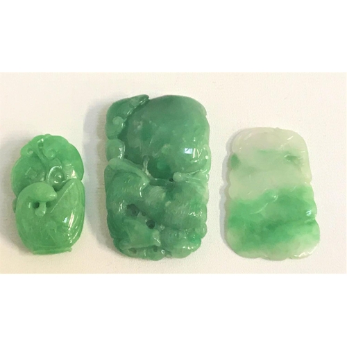 104 - THREE CARVED JADE AMULETS
the largest depicting a stylized horse above fruit, 7cm high; another with... 