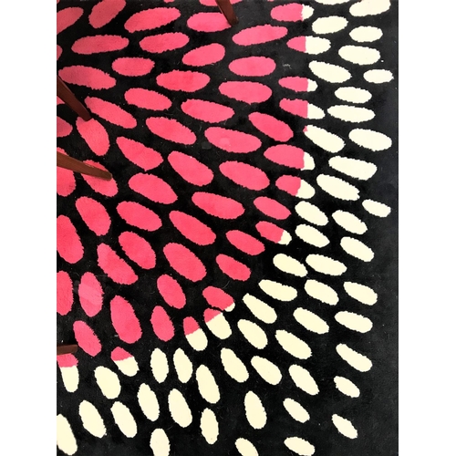 550 - LARGE BLACK GROUND RUG
with a central pink motif with a a white border, 200cm x 200cm