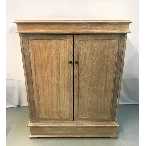 383 - LIMED OAK SIDE CABINET
with a moulded top above a pair of panelled cupboard doors opening to reveal ... 