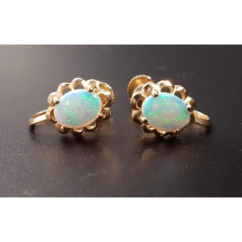 79 - PAIR OF OPAL EARRINGS
the oval opal on each within pierced lobed surround, in ten carat gold, with s... 