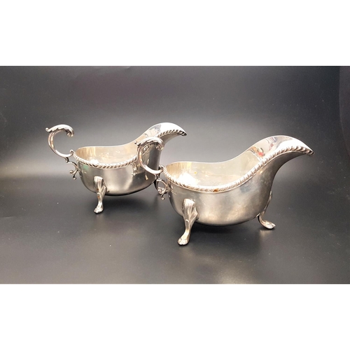 140 - PAIR OF EDWARD VIII SILVER SAUCE BOATS
both with shaped rims scroll handles and standing on three pa... 