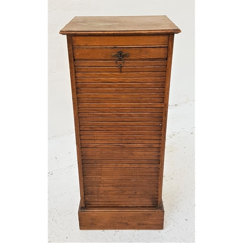 764 - OAK TAMBOUR FRONT MUSIC CABINET
with a drop down door revealing nine drawers, standing on a plinth b... 