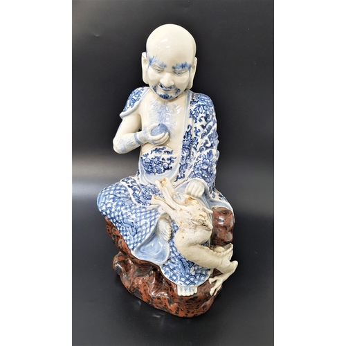 234 - CHINESE FIGURE ORNAMENT
depicting a man holding a pearl seated beside a dragon, with blue and white ... 