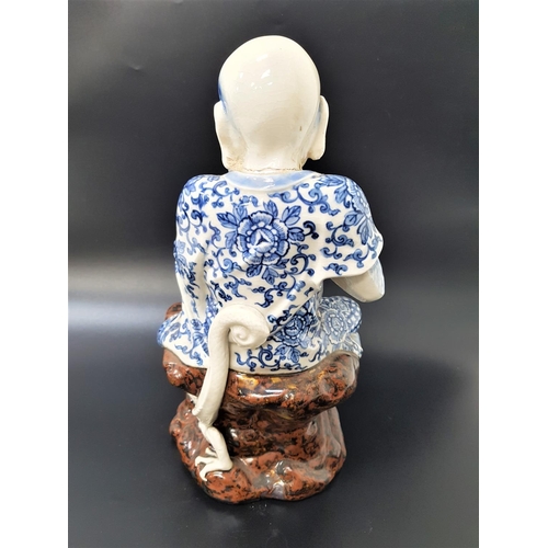 234 - CHINESE FIGURE ORNAMENT
depicting a man holding a pearl seated beside a dragon, with blue and white ... 