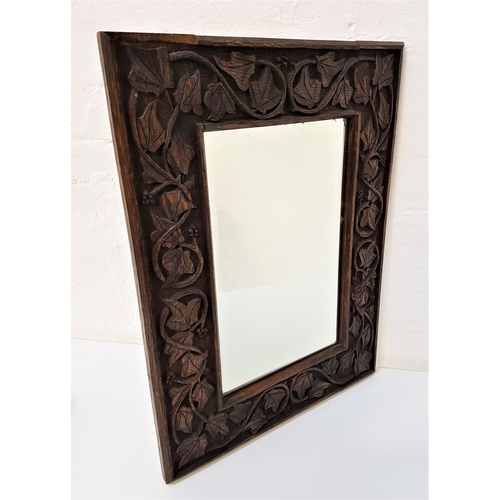 572 - CARVED OAK WALL MIRROR
with a rectangular beveled plate, the frame with carved fruiting vines, 60.5c... 