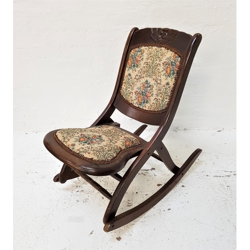 636 - EDWARDIAN MAHOGANY FOLDING ROCKING CHAIR
with a carved flower head top rail above a needle work padd... 