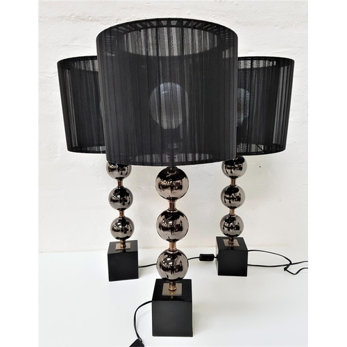 608 - SET OF THREE TABLE LAMPS
raised on a black square base with a metal column with three globes and a p... 