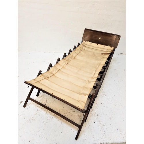 648 - CABINETTA CAMPAIGN BED
with concertina fold out action and a canvas base, with a fold down paneled f... 