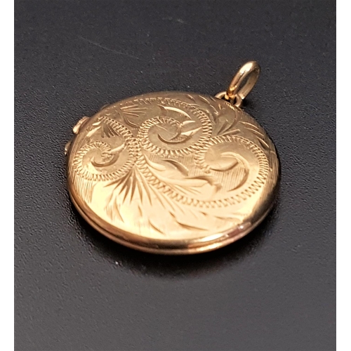 85 - NINE CARAT GOLD CIRCULAR LOCKET PENDANT
with engraved scroll decoration, 2.2cm diameter and approxim... 