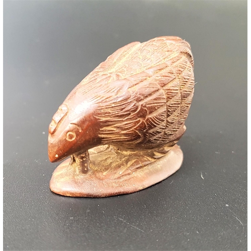 63 - JAPANESE HARDWOOD NETSUKE
depicting a chicken eating a worm from the earth, signed to base, 4.4cm lo... 