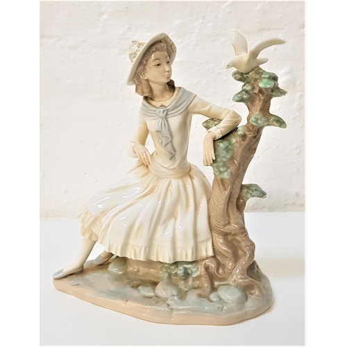 194 - NAO PORCELAIN FIGURINE
of a young girl seated by a tree looking at a dove, 24cm high