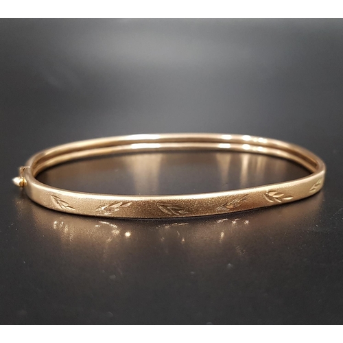 99 - UNMARKED GOLD BANGLE
with engraved detail to one side and safety clasp, approximately 4.3 grams