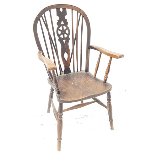 513 - 20th CENTURY OAK WHEELBACK ARM CHAIR
with an arched stick back and shaped arms above a shaped seat, ... 