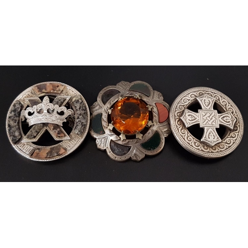 113 - THREE SCOTTISH UNMARKED SILVER BROOCHES
comprising a faceted amber glass and agate set example; anot... 