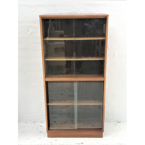 460 - TEAK BOOKCASE
with a rectangular moulded top above a pair of sliding glass doors with two adjustable... 