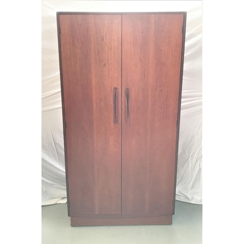 471 - G PLAN TEAK WARDROBE
with a pair of doors opening to reveal hanging space, standing on a plinth base... 