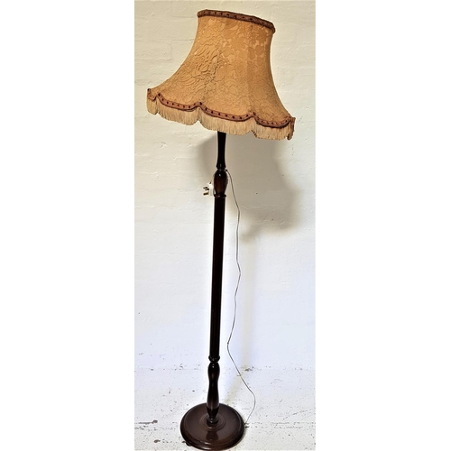 483 - MAHOGANY STANDARD LAMP
raised on a circular base with a turned column and shaped tasselled shade, 18... 