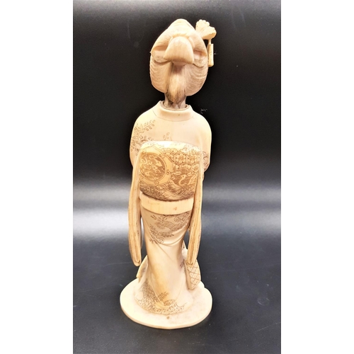 306 - JAPANESE IVORY OKIMONO OF A FEMALE MUSICIAN 
Meiji period, in traditional dress, holding a Tsubaki f... 