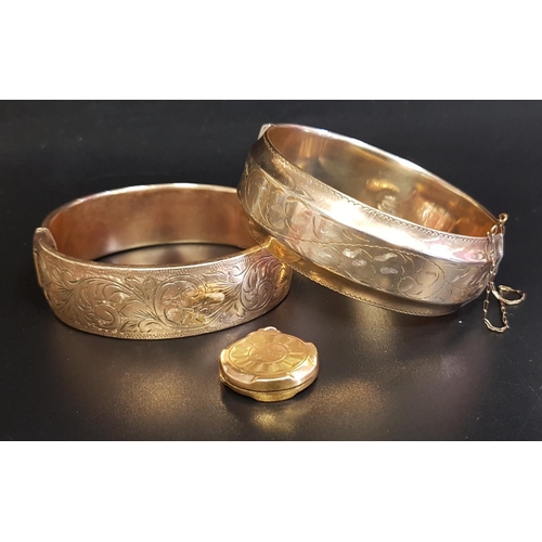 83 - TWO GOLD PLATED HINGED BANGLES
both with engraved scroll decoration, one with safety chain; together... 