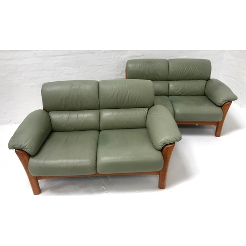 495 - PAIR OF SOFAS
covered in pale green leather with scroll arms, each being a two seater with a teak fr... 