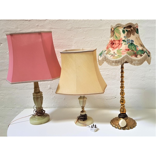 585 - TWO ALABASTER TABLE LAMPS
both with shades; together with a brass tapering table lamp (3)