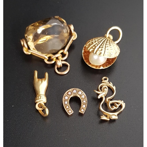 133 - FOUR GOLD CHARMS AND A SWIVEL FOB
the charms comprising an eighteen carat gold clam shell containing... 