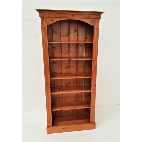 491 - WAXED PINE BOOKCASE
with a moulded cornice above five shelves, standing on a plinth base, 197cm high