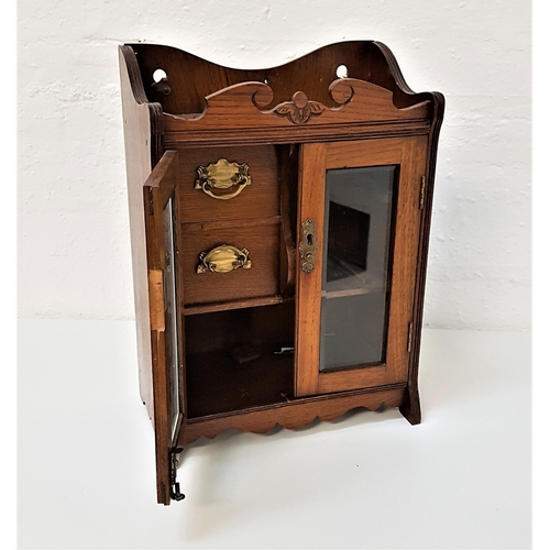 511 - EDWARDIAN OAK SMOKERS CABINET
with a shaped and carved top above a pair of bevelled glass doors open... 