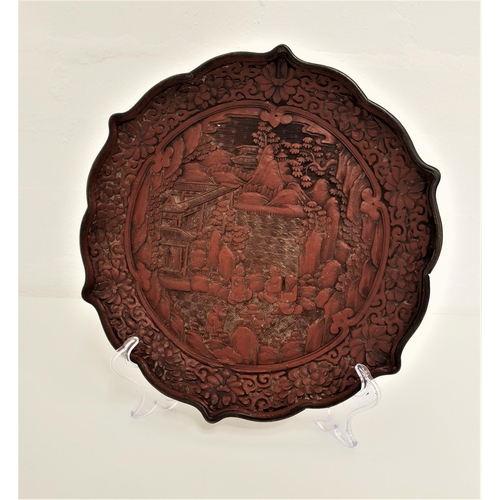 260 - QUING DYNASTY CINNABAR LACQUERED QUADRAFOIL DISH
carved in relief depicting figures by a pagoda, the... 