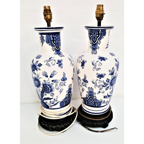 258 - PAIR OF DUTCH BLUE AND WHITE CHINA LAMPS
decorated with flowers, on carved circular wooden bases, 49... 