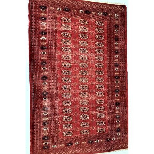 373 - BOKHARA RUG
with a deep red ground, the central section with geometric motifs, encased by a multi la... 