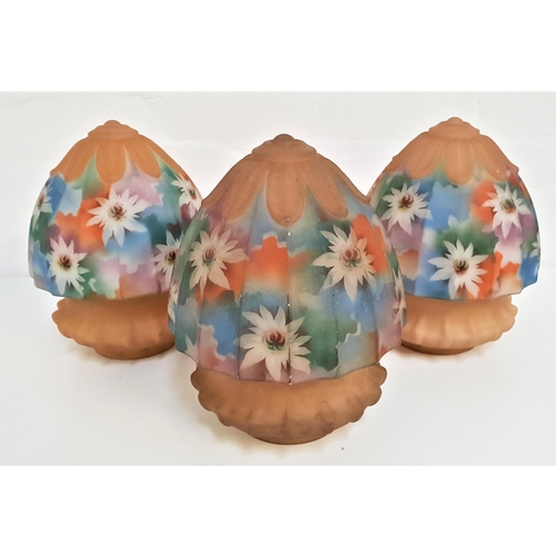 205 - THREE 1950s OPAQUE GLASS LIGHT SHADES
of conical form and decorated with brightly coloured flowers, ... 