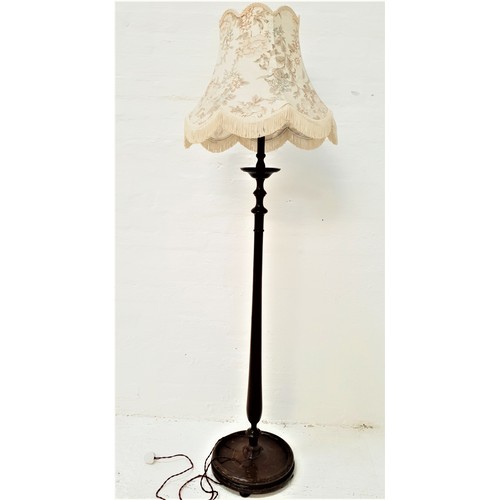 363 - STAINED OAK STANDARD LAMP
raised on a circular base with a turned column and a shaped tasseled shade... 