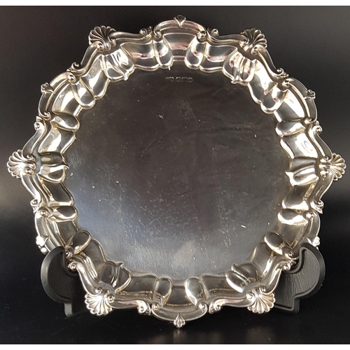 196 - EDWARD VII SILVER SALVER
of shaped circular outline with a shell and scroll border, on three scroll ... 