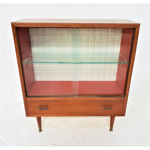 472 - 1970s TEAK DISPLAY CABINET
with a pair of glass sliding doors and a glass shelf, with a textured foa... 