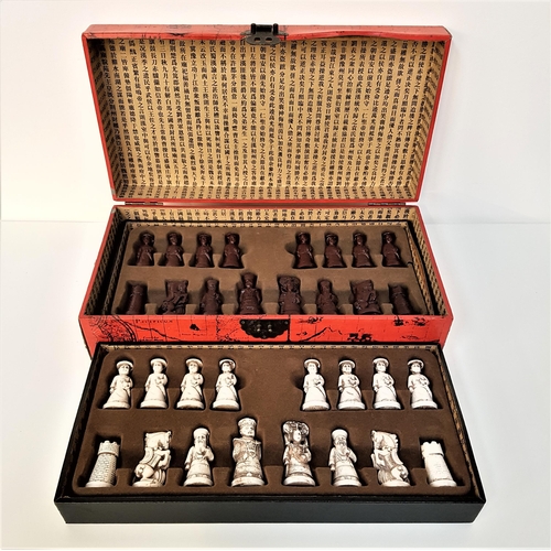 183 - CHINESE THEMED RESIN CHESS SET
of figures in white and deep red, in a fitted box with lift up lid an... 