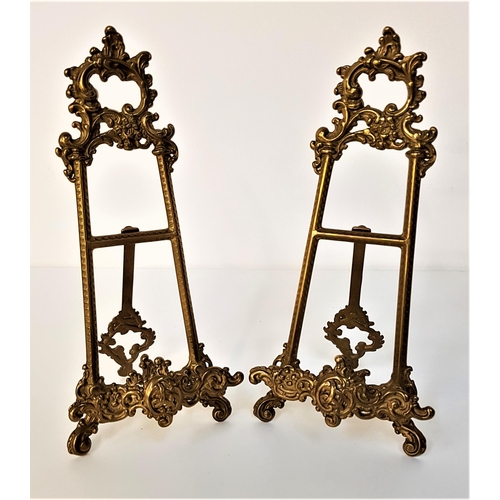 186 - PAIR OF SMALL GILT METAL EASELS 
with scroll decoration and a fixed rear support leg, 24cm high (2)