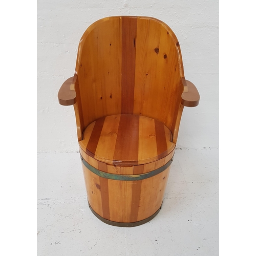 372 - PINE BARREL ARMCHAIR
with a shaped back and arms above a circular removable seat with storage below,... 