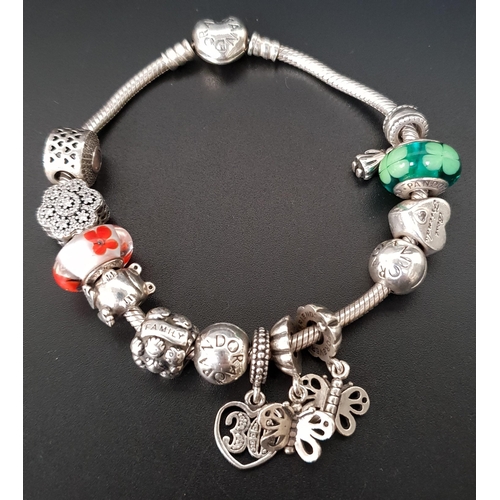 125 - PANDORA MOMENTS SILVER HEART CLASP CHARM BRACELET
with a good selection of eleven charms and one cli... 